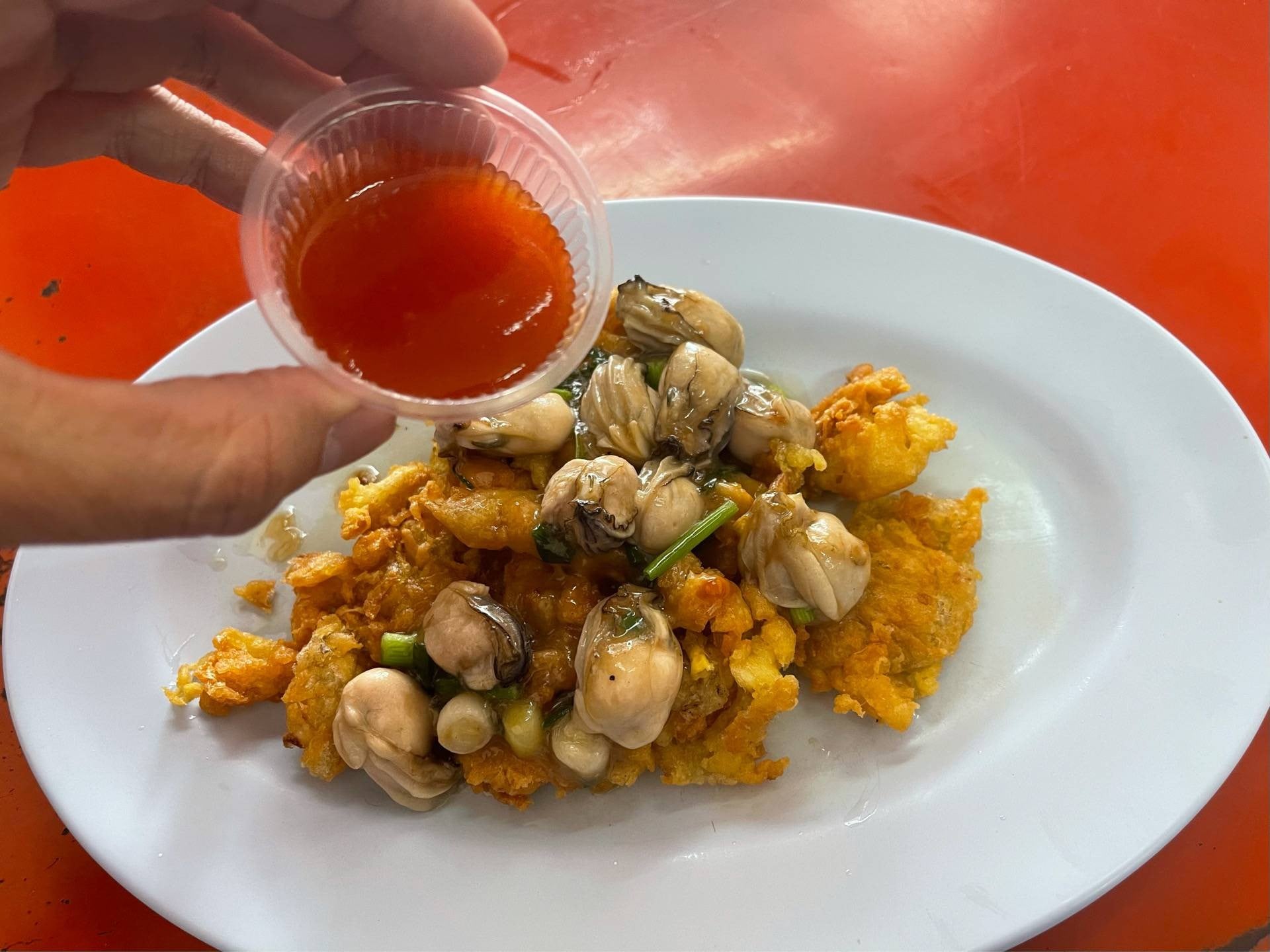จานหอยทอดออส่วนหอยนางรมตัวโตของร้านนายหมงหอยทอด เยาวราช พร้อมน้ำจิ้มสีส้ม