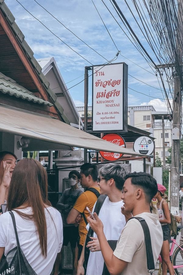 ป้ายร้านข้าวซอยแม่สาย (KHAOSOY MAESAI) และลูกค้าต่อแถวหน้าร้าน เชียงใหม่