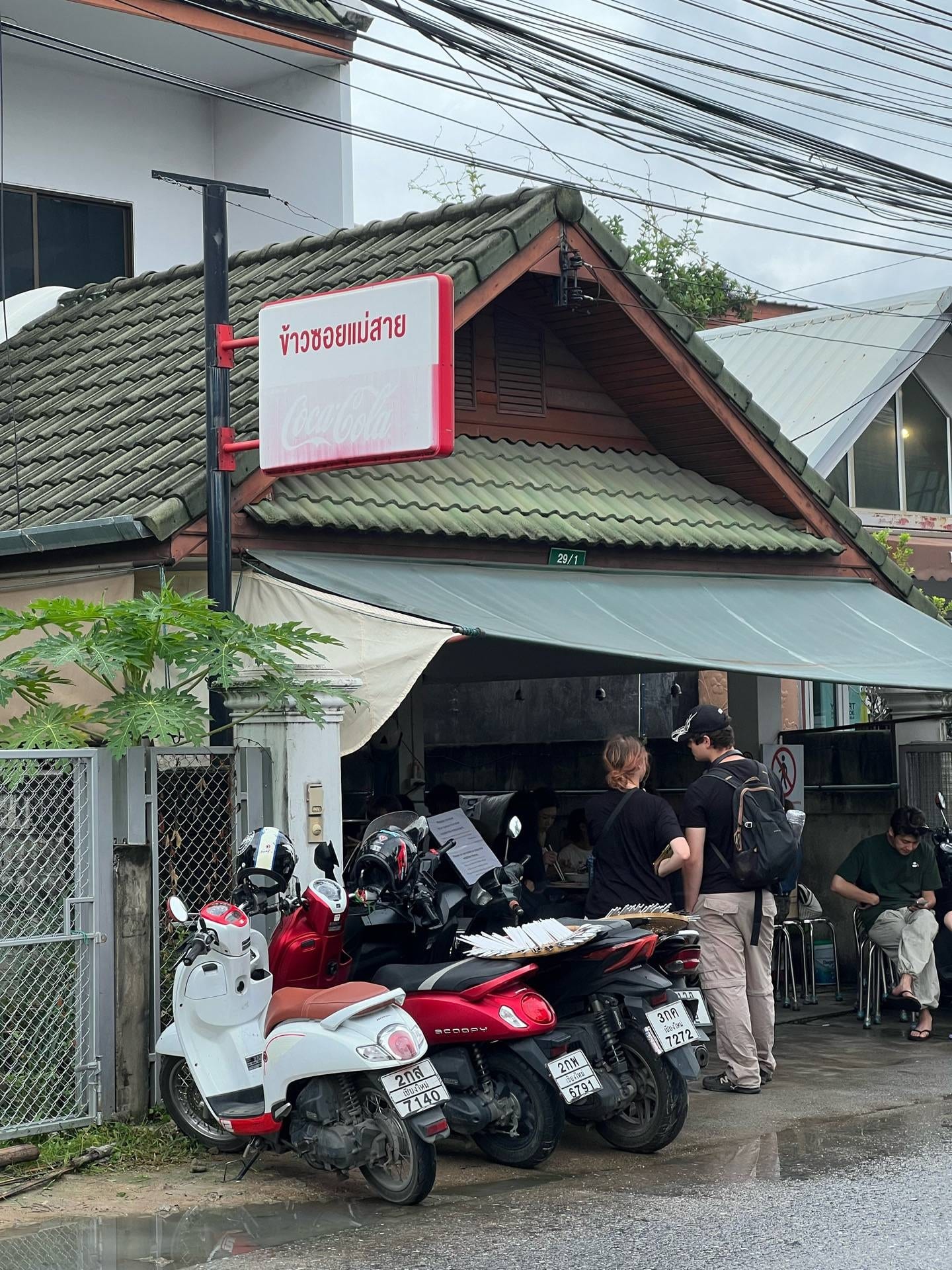 หน้าร้านข้าวซอยแม่สาย (ป้านะ) เชียงใหม่ ป้ายชื่อร้านสีแดงใต้หลังคากระเบื้องสีเขียวในซอยราชพฤกษ์