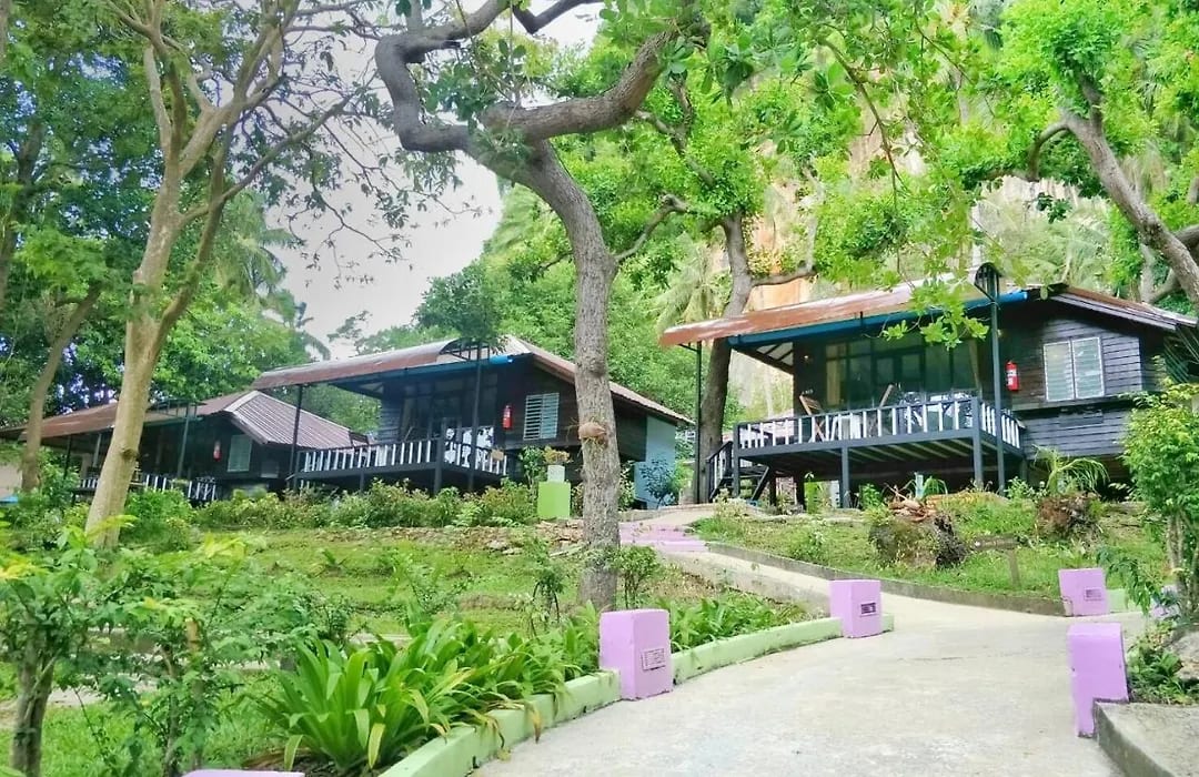 A wooden bungalow with a balcony at Anyavee Railay Resort among the limestone cliffs on Railay