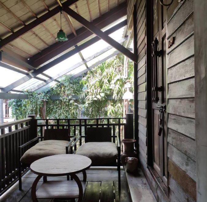 ห้องพักเรือนไม้สักของ Tamarind Guesthouse ผนังไม้สีมินต์ ตกแต่งด้วยผ้าไหม