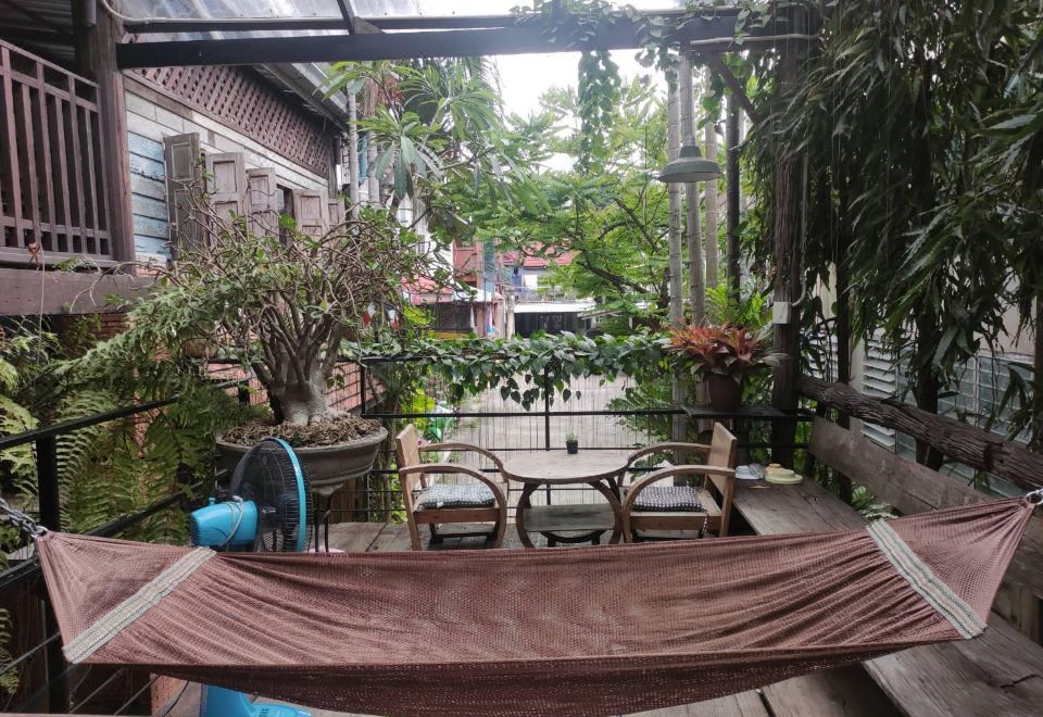 เฉลียงและพื้นที่นั่งเล่นไม้สักของ Tamarind Guesthouse อยุธยา
