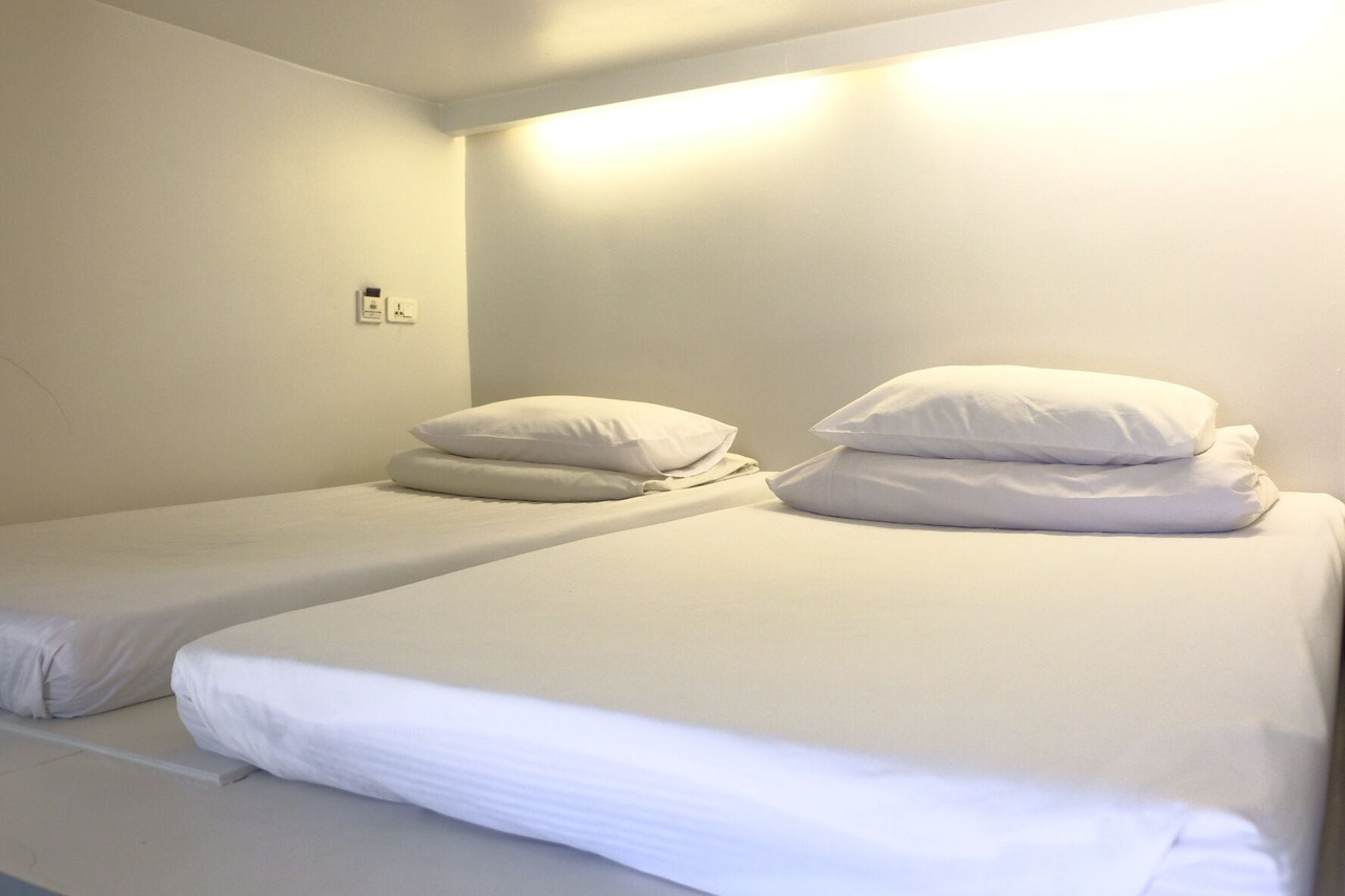 ห้องพักของ 3Howw Hostel Sukhumvit 21 ที่มีล็อกเกอร์และเตียงแคปซูลมีม่าน
