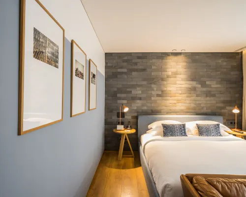 A guest room at Ad Lib Bangkok, decorated in warm natural tones with timber furniture and soft lighting
