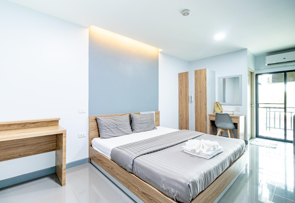 A clean, bright room at BeWish Residence Bangphlat with a balcony and natural light