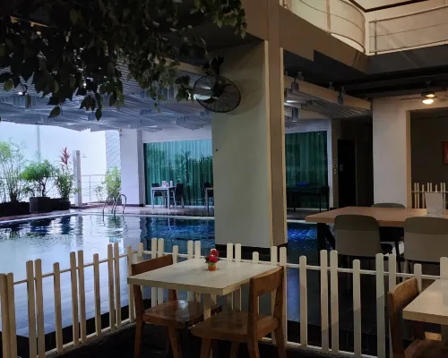 Brighton Suite Bangkok building exterior, grey and teal facade with rooftop signage