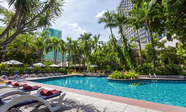 สระว่ายน้ำกลางแจ้งของ Centara Grand at Central Plaza Ladprao Bangkok พร้อมเก้าอี้ผ่อนคลายรอบสระ