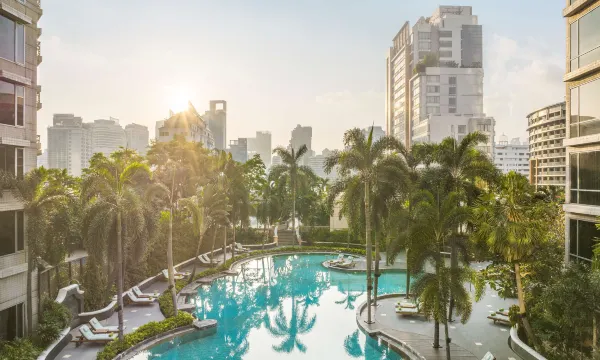 สระว่ายน้ำ outdoor ชั้น 7 ของ Conrad Bangkok บรรยากาศ tropical ล้อมด้วยปาล์มและลานไม้