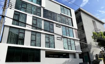 สระว่ายน้ำกลางแจ้งของ Fullrich Residence กรุงเทพ ล้อมรอบด้วยต้นไม้และพื้นที่นั่งเล่น