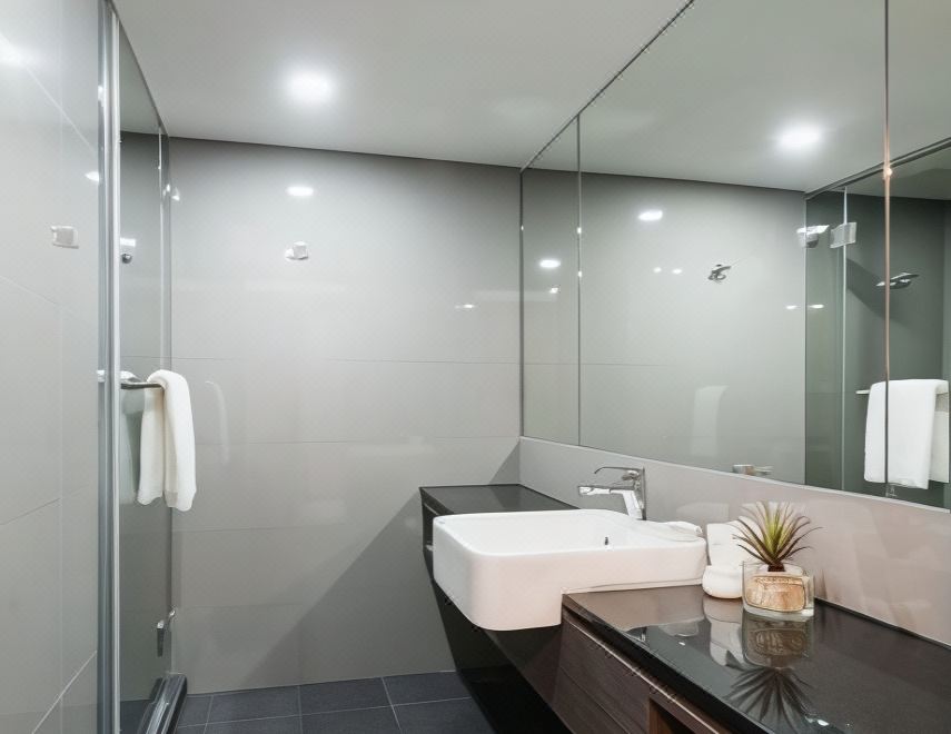 A guest bathroom at fyn hotel Bangkok, clean white tiles and a separate shower zone