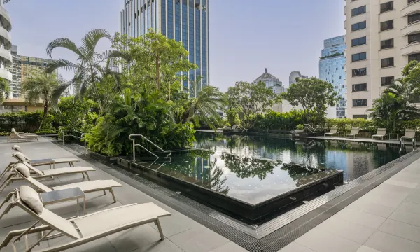 สระว่ายน้ำกลางแจ้งในสวนของ Grande Centre Point Ratchadamri Bangkok ท่ามกลางต้นไม้ใจกลางเมือง