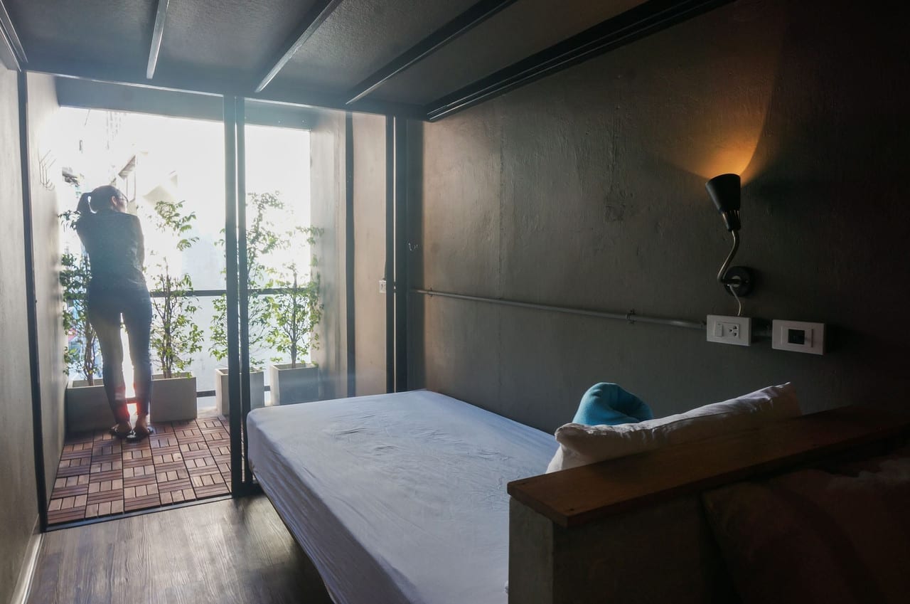 มุมล็อบบี้และพื้นที่ส่วนกลางของ In a Box Hostel ตกแต่งสไตล์อินดัสเทรียลโทนปูนเปลือยและไม้
