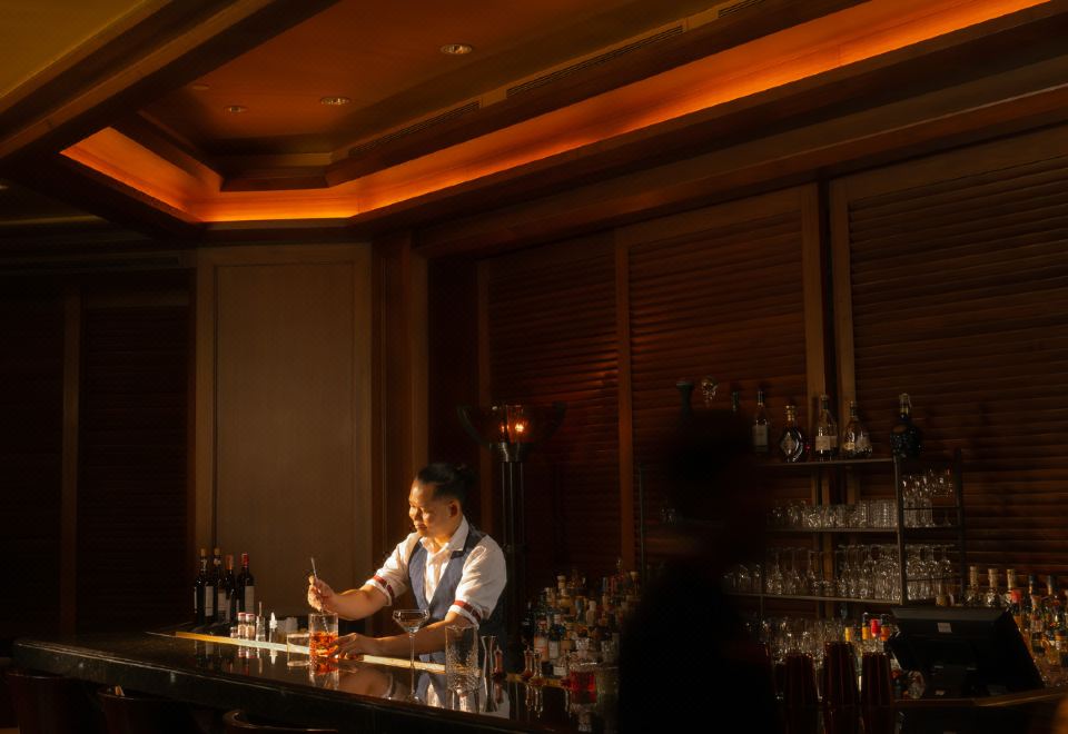 บาร์ริมแม่น้ำของ The Peninsula Bangkok ยามค่ำคืน แสงไฟสะท้อนผิวน้ำ