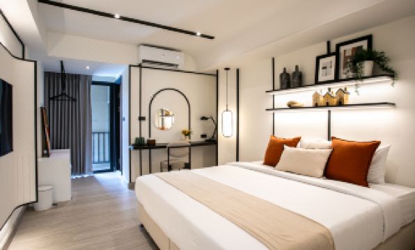 ห้อง Deluxe Twin ของ Pillow B Hotel เตียงสองหลังผ้าปูขาวใหม่ ผนังโทนเบจอบอุ่น
