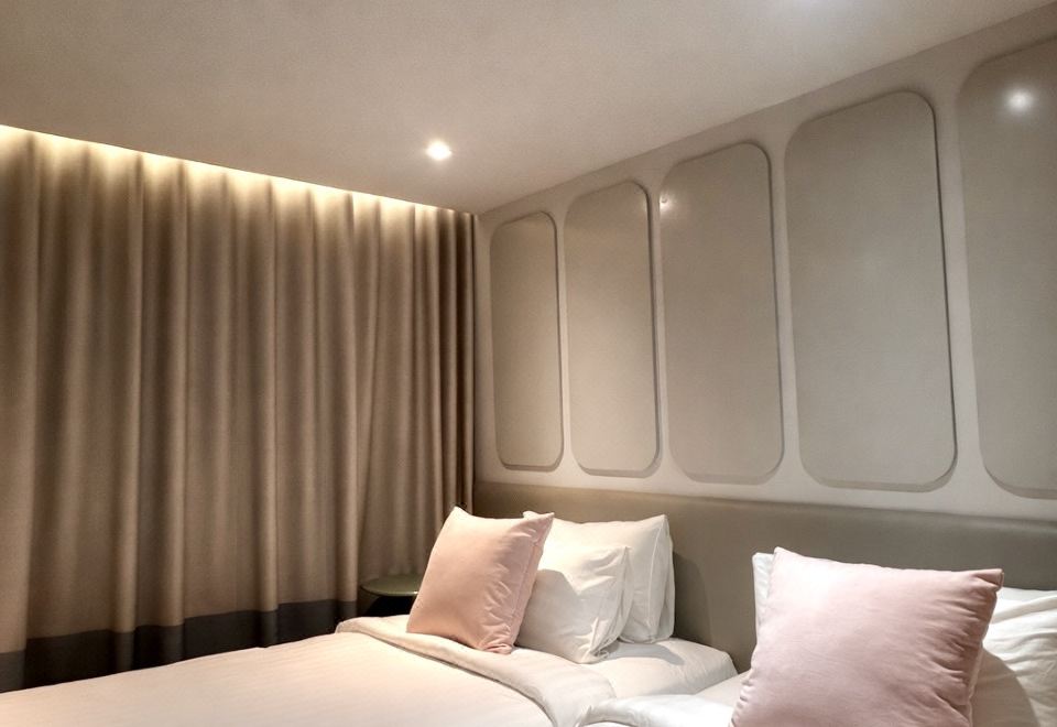 Guest room at The Quarter Ladprao by UHG Bangkok, modern furnishings with king bed and 49-inch Smart TV