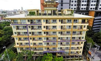 Spacious suite at Sarasinee All Suite Bangkok with sofa lounge area, flat-screen TV and kitchenette