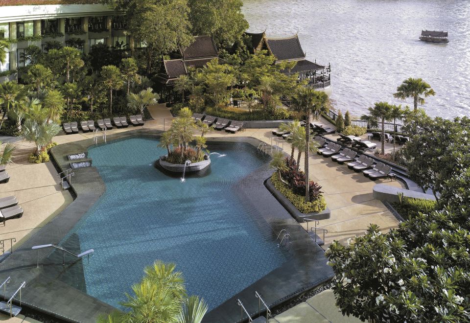 สระว่ายน้ำกลางแจ้งของ Shangri-La Bangkok ล้อมรอบด้วยสวนเขตร้อนริมเจ้าพระยา