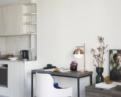Kitchen corner and work desk in a Somerset Rama 9 apartment unit, with built-in kitchen and clean minimalist design