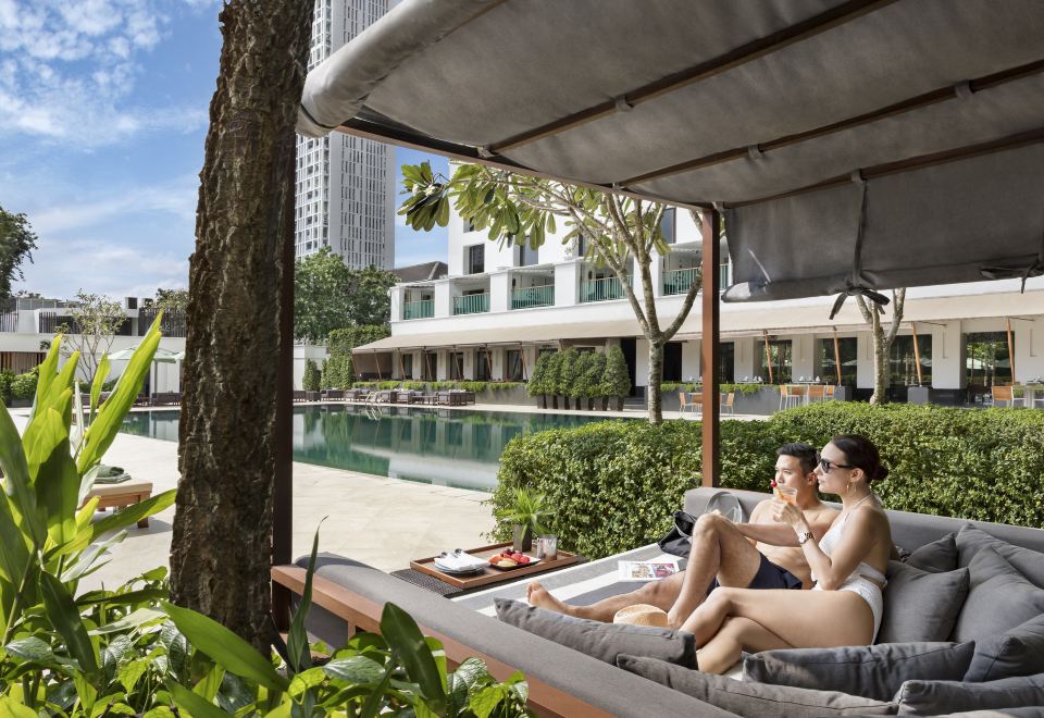 A Deluxe Room at The Sukhothai Bangkok — teak floors, Thai craft furniture and a separate bathtub