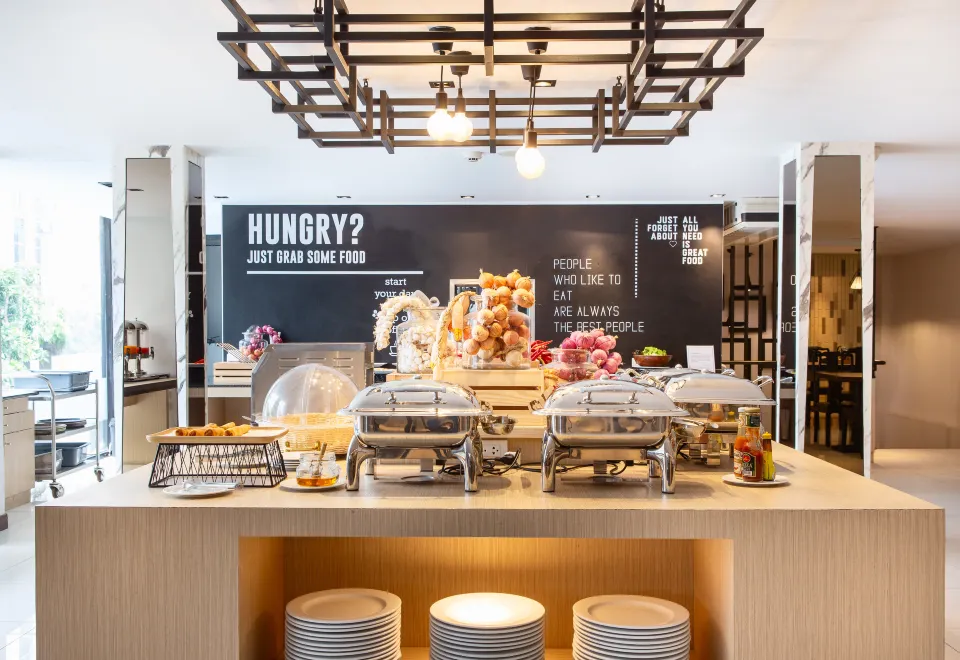 The breakfast restaurant at Three Sukhumvit Hotel with modern decor and a buffet spread