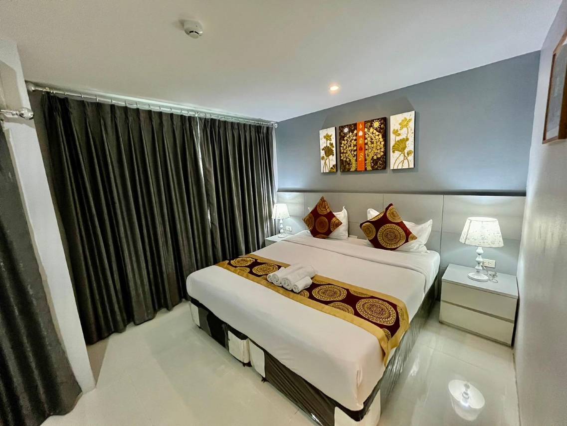 ห้อง Deluxe Double ของ Top High Airport Link Hotel ผนังโทนฟ้าเทา เตียงใหญ่พร้อมผ้าคาดลายทอง