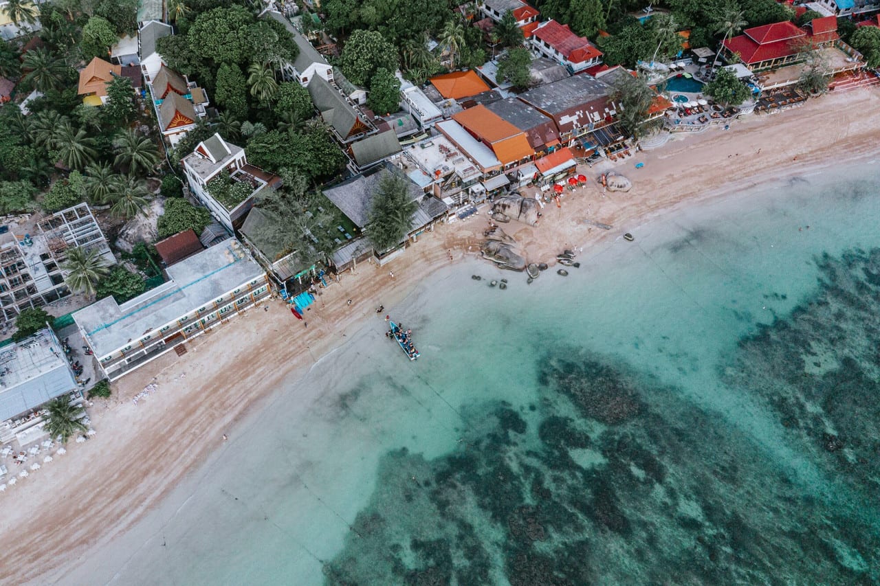 หาดทรายรีหน้ารีสอร์ตพร้อมร้านอาหารริมหาดและวิวพระอาทิตย์ตกของ Ban's Diving Resort