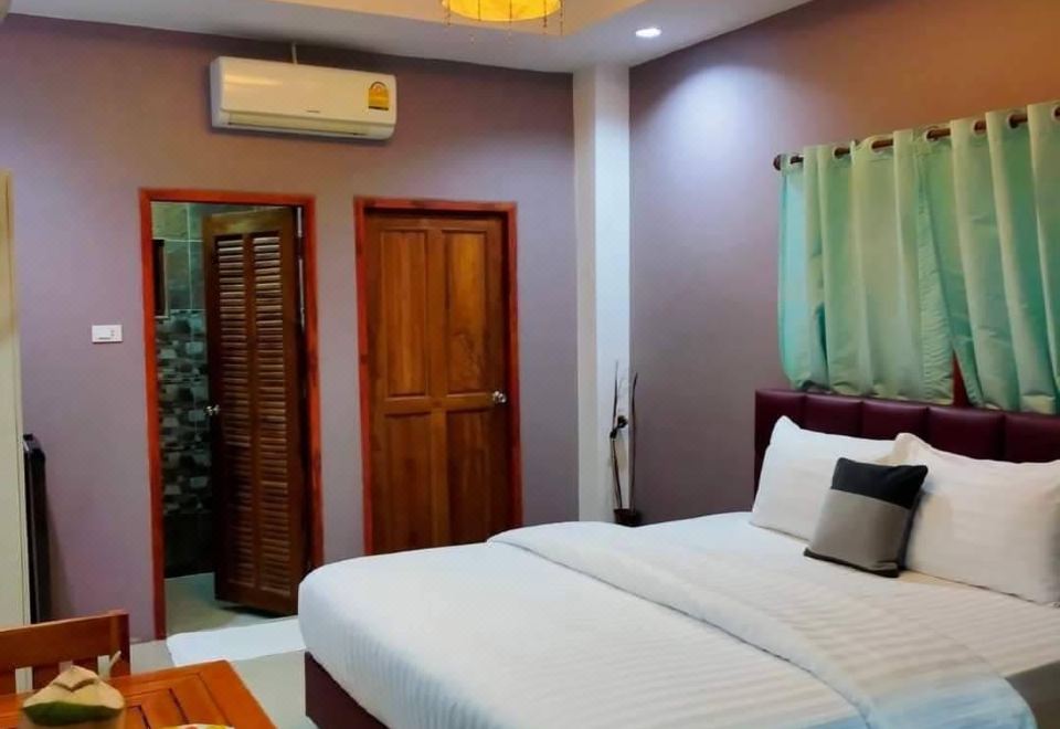 ห้องพัก M Grand Hotel บึงกาฬ เตียงนอนกว้าง โทนสีอบอุ่น มีตู้เย็นและทีวี