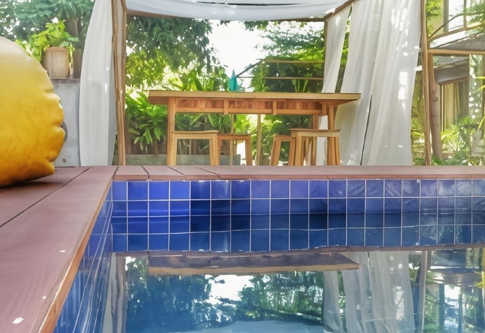 สระว่ายน้ำกลางแจ้งของ Klim Hotel บุรีรัมย์ อยู่ระหว่างอาคารปูนเปลือยสองหลัง