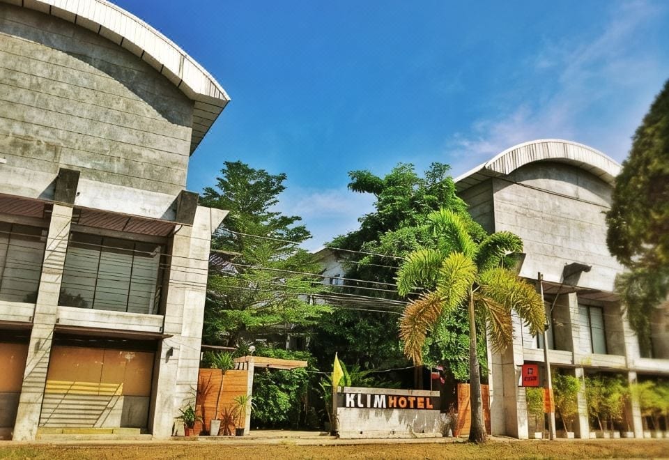 ห้องพักของ Klim Hotel บุรีรัมย์ ผนังปูนเปลือยมินิมอลพร้อมงานวาดหัวเตียง