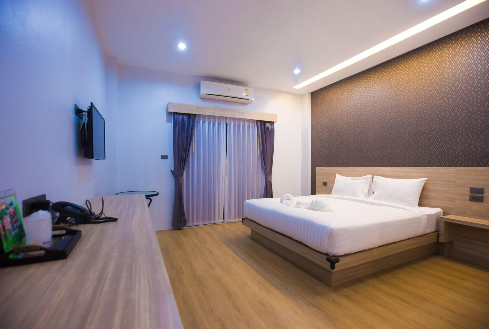 ห้องพักของ The S.G. Hotel Buriram พร้อมเตียงและทีวีจอแบนโทนเรียบ