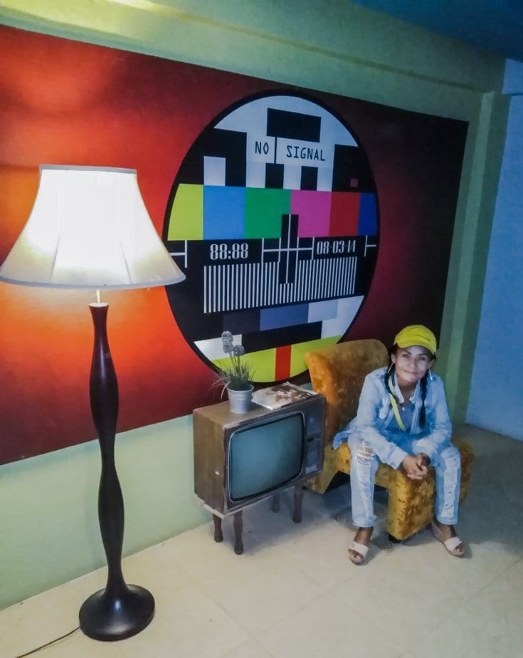 คาเฟ่และพื้นที่นั่งเล่นชั้นล่างของ The Chill Classic House พร้อมมุมถ่ายรูปลายแผนที่โลกและโต๊ะปิงปอง