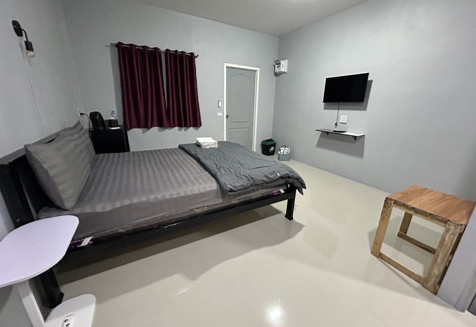ห้องพักภายในบังกะโลพร้อมเตียง เครื่องปรับอากาศ และทีวี