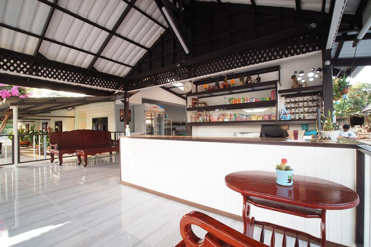ห้องพักภายในพร้อมเตียง เครื่องปรับอากาศ และที่จอดรถหน้าห้อง