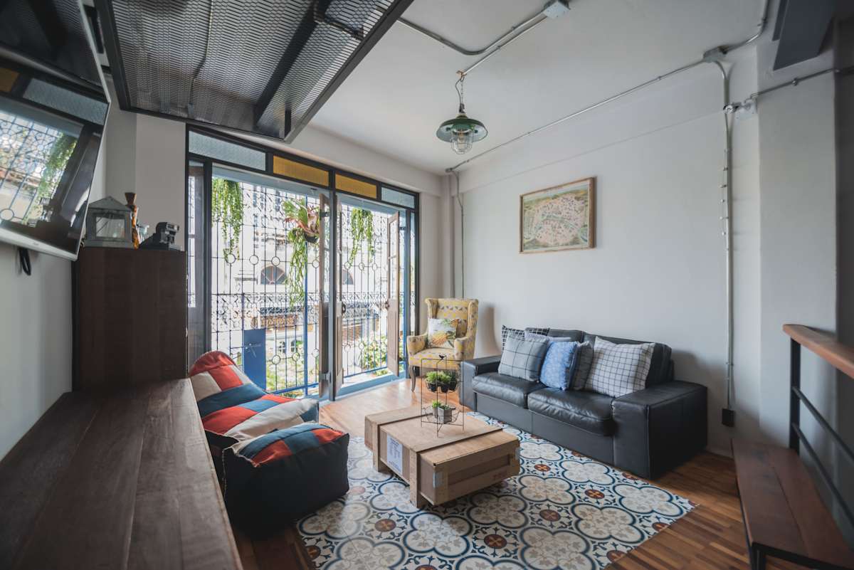 มุมนั่งเล่นส่วนกลางของ Chernchan Hostel จันทบุรี ตกแต่งสไตล์ฮิปด้วยอิฐเปลือยและของแต่งผนัง