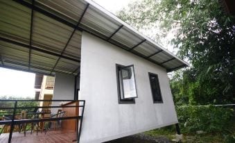 ห้องพักติดแอร์พร้อมระเบียงส่วนตัวมองออกสู่สวนของ Our Eco Farm ต.ปัถวี จันทบุรี