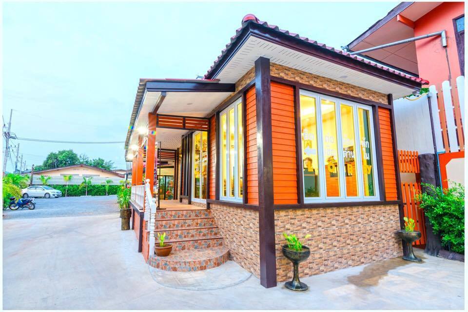 อาคารต้อนรับและล็อบบี้ของ Nakhonchanthani Hotel ขลุง ตกแต่งโทนไม้และส้มอิฐ กระจกใสรอบด้าน สะอาดตา