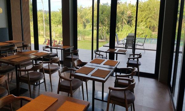 ห้องอาหารและพื้นที่ส่วนกลางของ Riverawan Hotel มองออกไปเห็นแม่น้ำ