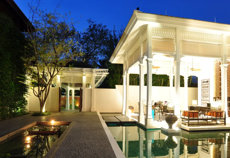 สระว่ายน้ำกลางแจ้งยาว 25 เมตรของ 137 Pillars House ล้อมรอบด้วยกำแพงต้นไม้สีเขียวสูง
