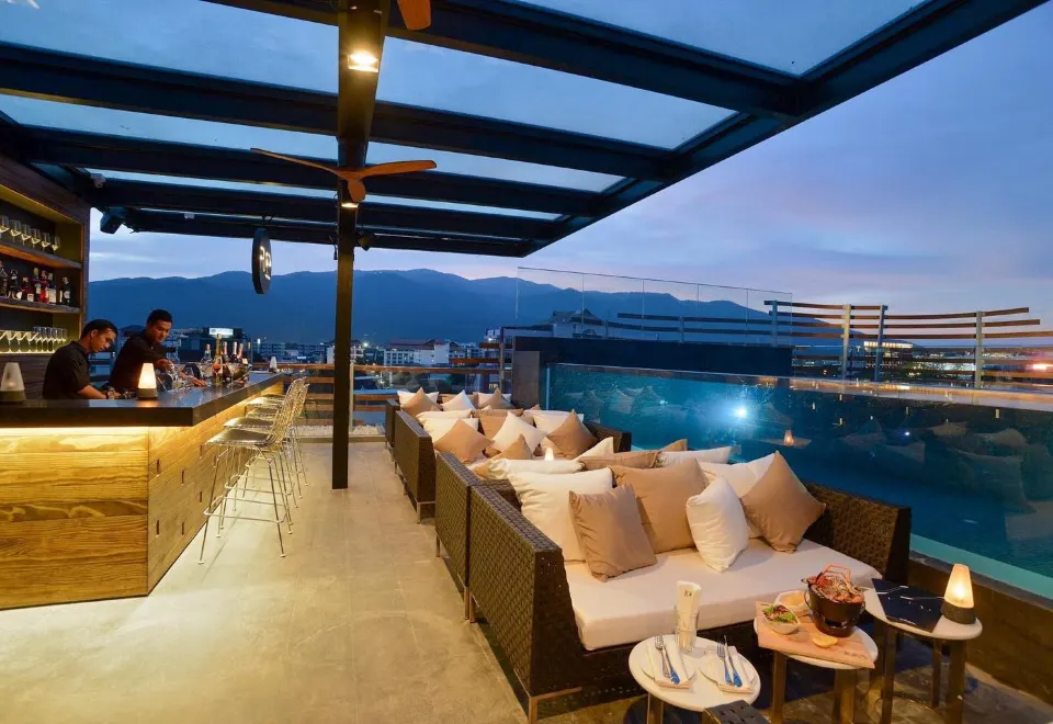 ARISE Rooftop Bar บนดาดฟ้ายามค่ำ ไฟสลัวและที่นั่งริมสระ