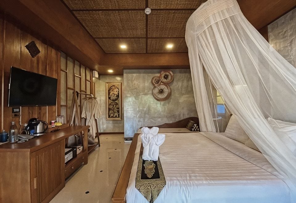 ห้องพักของ Busara Chiangmai Hotel ตกแต่งโทนสว่าง เตียงนุ่ม มีโต๊ะทำงานริมหน้าต่าง