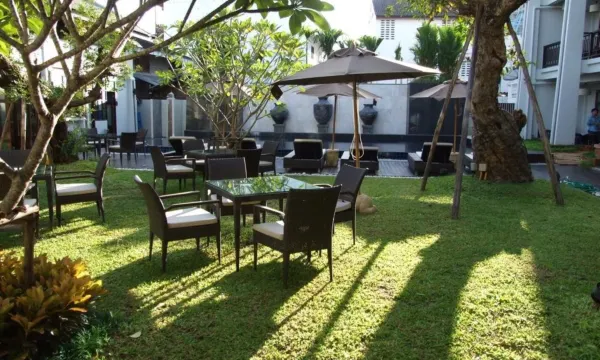 อาคารหลังคาจั่วทรงล้านนาของโรงแรมท่ามกลางต้นไม้เขียวในเมืองเก่า