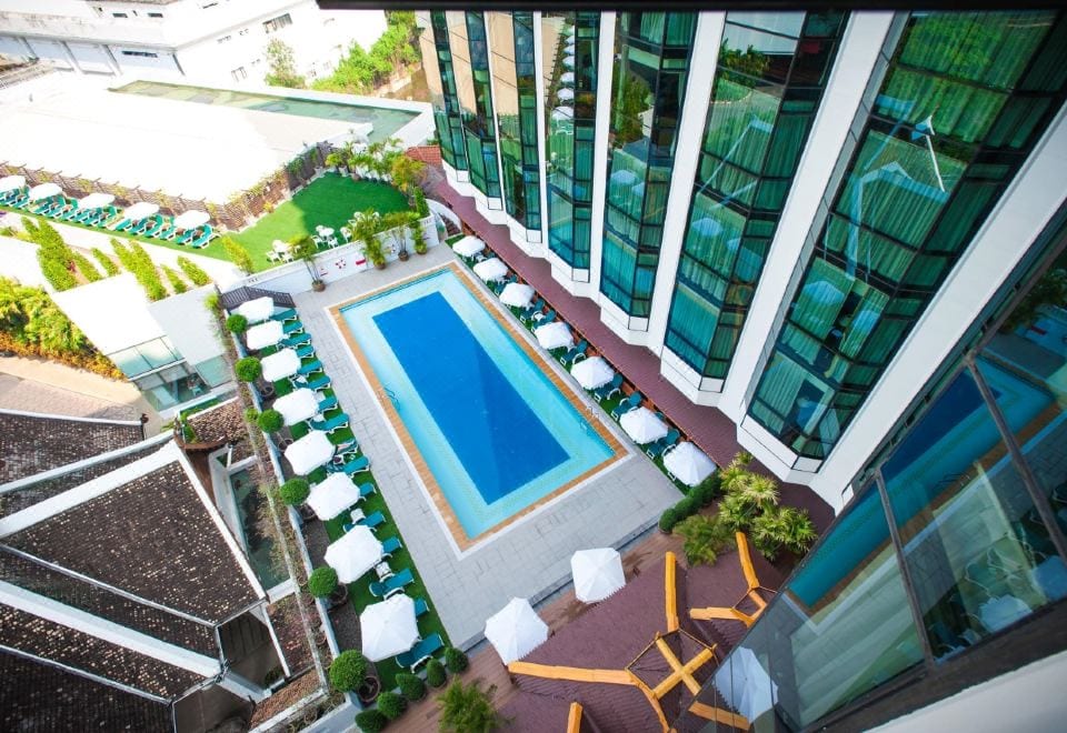 สระว่ายน้ำกลางแจ้งขนาดใหญ่ของ The Empress Hotel Chiang Mai พร้อมเตียงอาบแดด