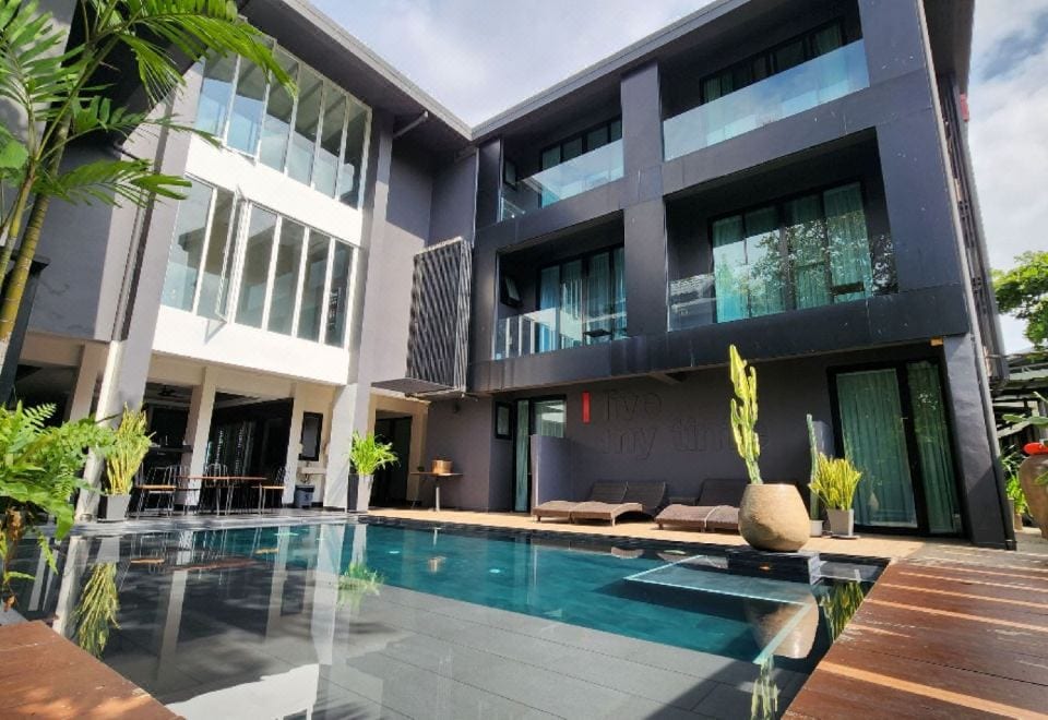 สระว่ายน้ำเกลือกลางแจ้งของ iWualai Hotel ล้อมรอบด้วยสวนและที่นั่งรับแดด
