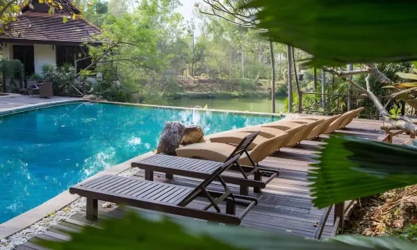 สระว่ายน้ำกลางแจ้งของ Jirung Health Village ท่ามกลางสวนเขียว