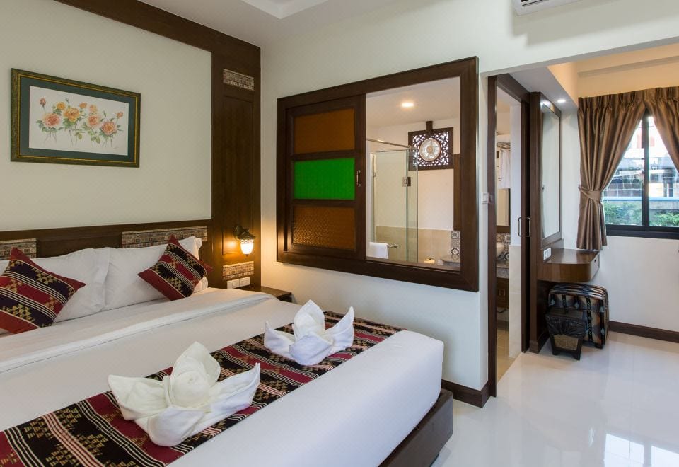 ห้องพักโทนอบอุ่นของ Mhonsa Hotel พร้อมเตียงนุ่มและทีวีจอแบน