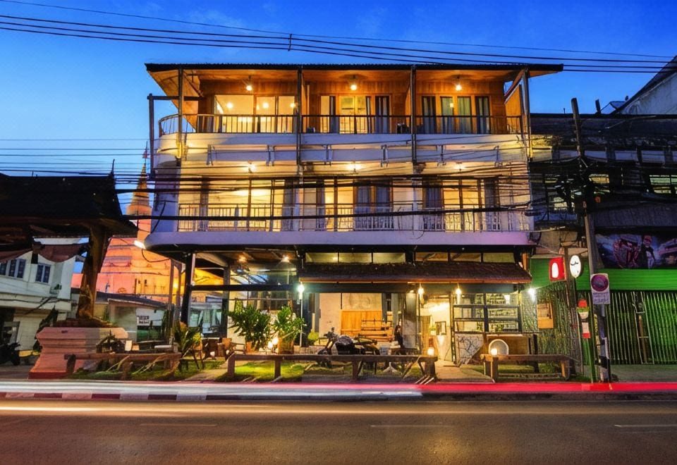 ห้องพักตกแต่งไม้สักของ Sri Chiang Yeun House เตียงและผ้าปูโทนอุ่น