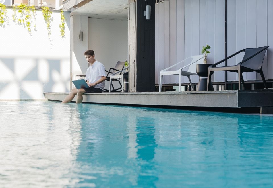 สระว่ายน้ำกลางแจ้งของ The Core Gallery Hotel เชียงใหม่ ล้อมรอบด้วยอาคารและต้นไม้