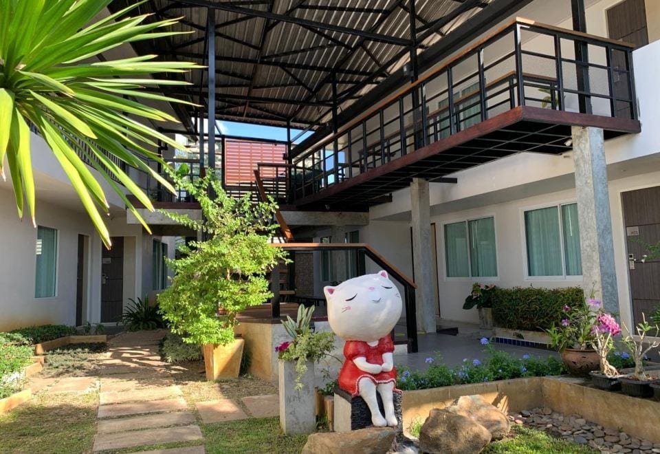 อาคารด้านนอกและสวนของ Homey Dormy Chiangrai ในย่านรอบเวียงเชียงราย