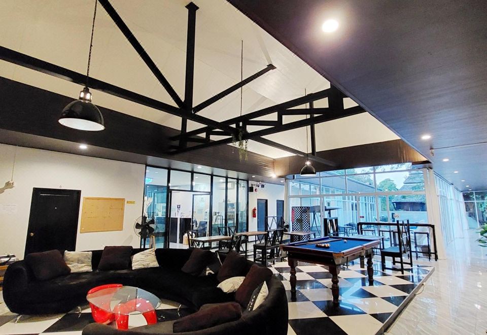 ห้องพักสะอาดโทนสว่างของ Mercy Hostel พร้อมเตียงและพื้นที่นั่งเล่น