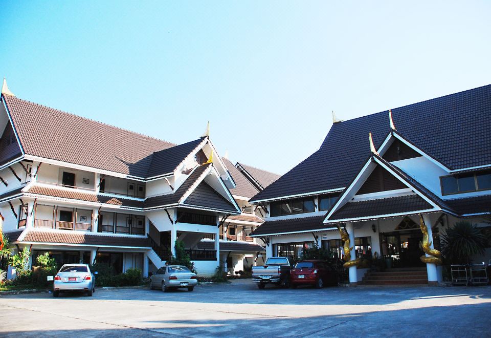 สระว่ายน้ำกลางแจ้งของ Nak Nakara Hotel ล้อมรอบด้วยสวนและอาคารสไตล์ล้านนา